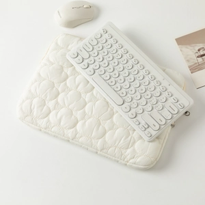 Detailed texture of quilted cloud laptop sleeve with wireless keyboard and mouse