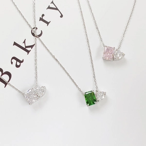 Macro shot of S925 silver necklaces with emerald, pink, and white square cut stones