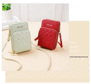 Detailed view of triple-layer zipper structure on heart-quilted crossbody phone bags