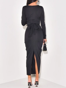 Back view of elegant black long evening dress with waist bow and rear slit detail