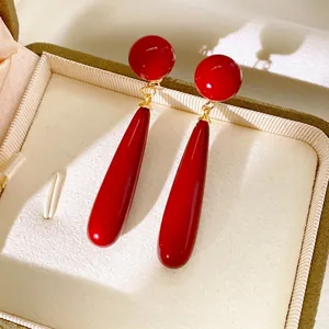Elegant red resin waterdrop earrings with gold finish in a premium velvet jewelry box