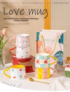 Detail of creative ceramic mug with heart handle and hand-painted grid floral patterns