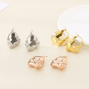 Macro detail of irregular 18K gold and silver earrings with liquid metal molten texture
