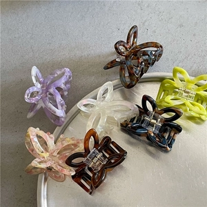 Selection of colorful acetate butterfly hair claws with marbled patterns on metal tray