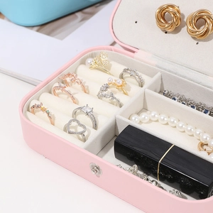 Close-up of pink jewelry box interior with ring slots and earring compartments