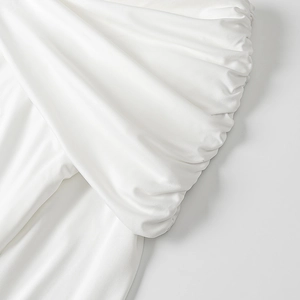 Detail view of the white mesh fabric with elegant pleated texture and soft drapes