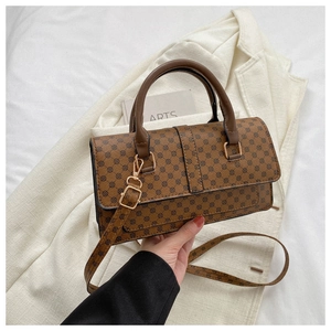 Detail of vintage brown litchi pattern handbag with gold hardware and leather handles