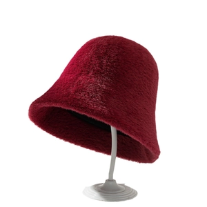 Elegant wine red faux fur bucket hat for women on white display stand with soft texture