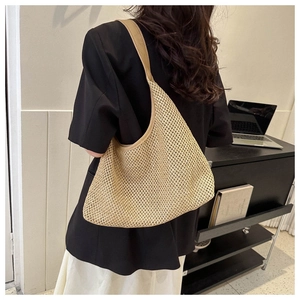 Detail of a beige woven tote bag mesh texture shown in an aesthetic office setting