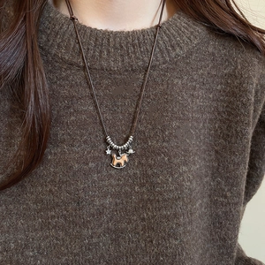 Close-up of wooden horse pendant with star charms and beads on brown cord necklace