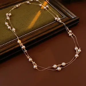 French vintage double-layered necklace with champagne pearls and clear crystals on a wood frame