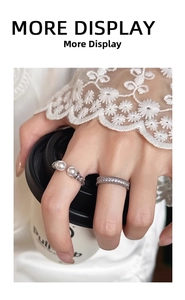 Detail view of pearl open ring and pavé zircon band worn by a model with a coffee cup
