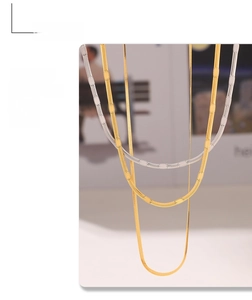 Detailed view of flat blade snake chains in gold and silver stainless steel finish