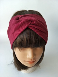 Close-up of ribbed knit elastic headband in dark red featuring a twisted knot design