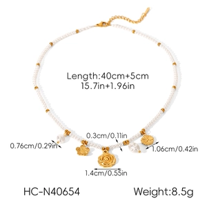Macro view of stainless steel pearl necklace with sunflower and coin pendants