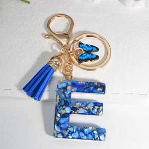 Royal blue resin letter E keychain with gold flakes, tassel and butterfly charm