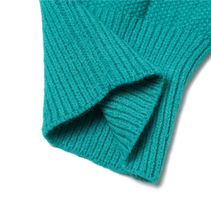 Close-up macro shot of the green knitted texture and cuff detail on winter scarf hat