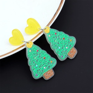 Gros plan de boucles d'oreilles sapin de Noël en acrylique vert avec points colorés