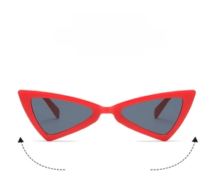 Detail of red cat-eye sunglasses with bold triangular frames and dark gray lenses