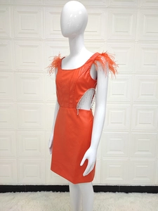 Détail de la robe mini en PU orange avec plumes, découpes et franges en strass