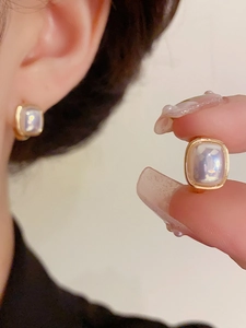 Close-up and on-model view of square iridescent pearl earrings in gold finish
