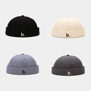 Detailoverzicht van katoenen docker caps in vier kleuren met letter b borduursel
