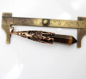 Detail van een 80mm tijgeroog kristallen hanger met koperen filigraan kapje