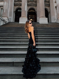 Close-up of the detailed 3D floral petals and tiered texture on black strapless gown
