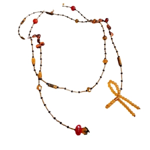 Beaded bow necklace with amber and mushroom charms in a retro boho vintage style