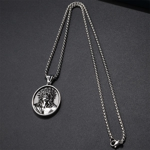 Detail of vintage silver stainless steel religious pendant with embossed Jesus figure