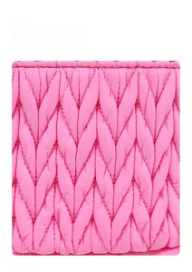 Macro shot of pink quilted fabric with V-shaped stitching on a large makeup bag