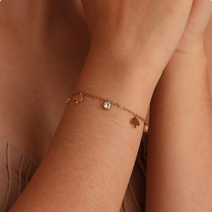 Elegante bracciale a catena dorata con ciondolo albero e zircone al polso donna