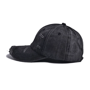 Detailed view of the distressed edges and ripped holes on this washed black baseball cap
