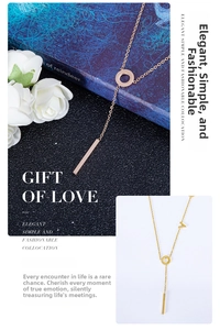 Detail of titanium steel Y-shaped necklace with ring and vertical bar in rose gold and gold