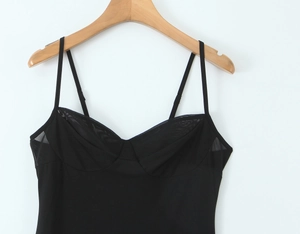 Detail of black camisole dress featuring mesh patchwork and slim spaghetti straps