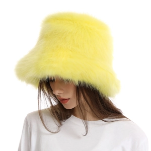 Close-up detail of soft faux fox fur texture on the vibrant yellow winter bucket hat