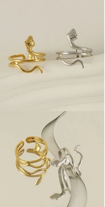 Detailed view of gold and silver snake rings with polished finish and adjustable bands