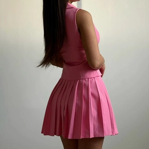 Détail de l'ensemble sans manches rose avec mini-jupe plissée assortie sur un mannequin