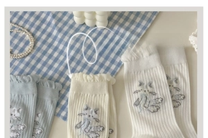 Détail de chaussettes mi-mollet style japonais avec bordure en dentelle et broderie chaton