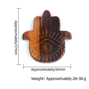 Tiger eye stone Hamsa Hand palm pendant with engraved eye pattern on white background