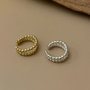 Double-layered minimalist metal bead open ring in gold and silver finish on warm background