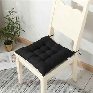 Thick black quilted chair cushion with ties on a white wooden chair for home office use