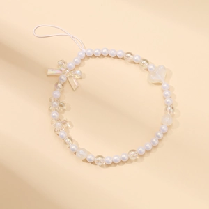 Detail of beaded phone strap with white pearls and clear acrylic heart bow charms