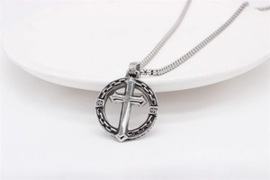 Macro d'un pendentif croix argenté rétro avec motif de chaîne et collier à billes