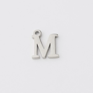 Macro view of a silver mirror-polished stainless steel capital letter M pendant