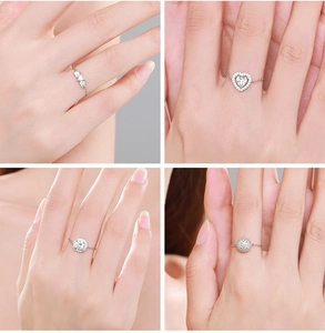 Close-up of four S925 silver chain rings with heart and zircon accents on a finger