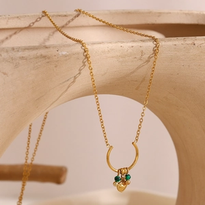 Vintage 18K gold plated stainless steel U-shaped heart necklace on sculptural ceramic