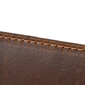 Macro shot of brown leather texture and stitching on a tri-fold wallet detail