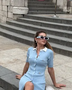 Detail of light blue knit dress featuring white contrast collar and button row design