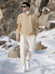 Detail of beige waffle knit quarter-zip jacket with contrast brown elbow patches